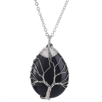 Black stone pendant with silver wire wrapping on a chain against a white background