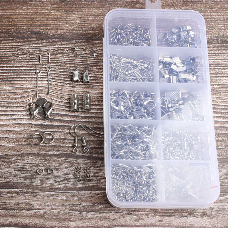 Clear plastic box with jewelry components on a wooden surface