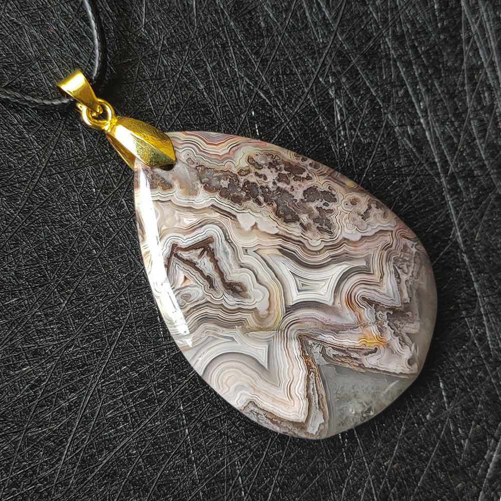 Mexican Crazy Agate gemstone pendant on neutral background