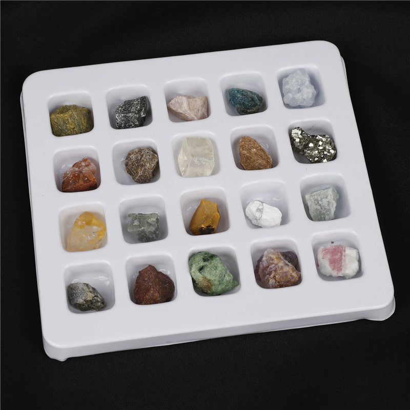 Set of various colored rocks in a white tray on a black background