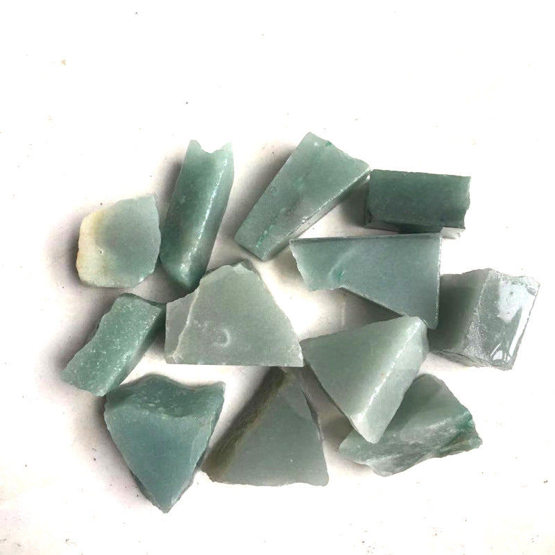 Collection of greenish-blue stone chips on a white background