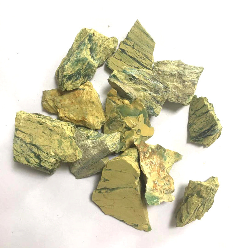 Pile of greenish-brown mineral fragments on a white background