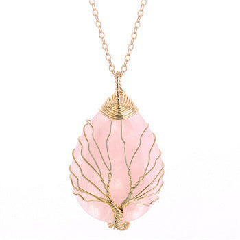 Necklace with a pink teardrop-shaped pendant and gold tree design on a white background
