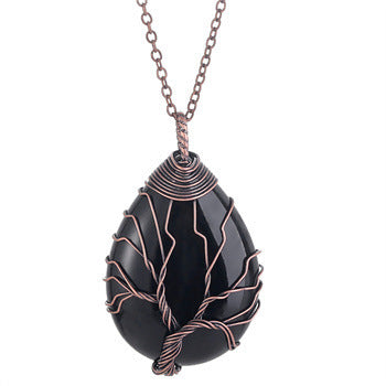Black teardrop-shaped pendant with copper wire wrapping on a chain against a white background
