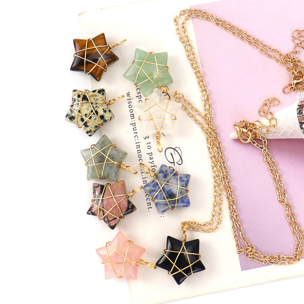 Star-shaped stone pendants with gold chains on a white surface